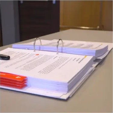 Teilnehmerhandbuch mit Schulungsunterlagen auf dem Kurstisch