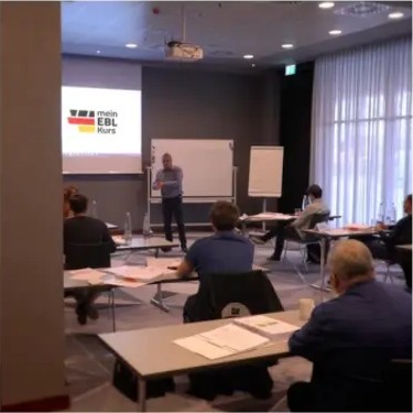 Dozent beim Präsenzunterricht vor der Kursgruppe