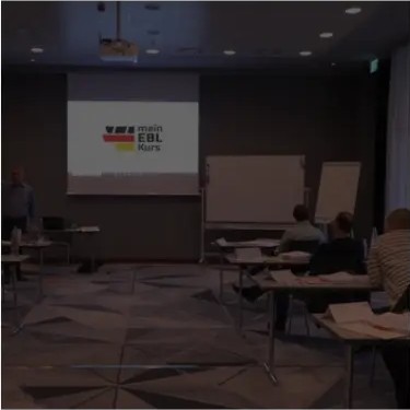 Teilnehmer im Kursraum während eines Vortrags